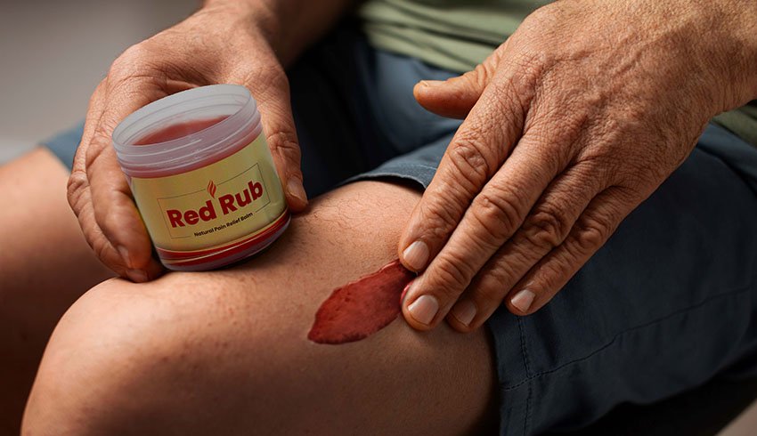 an old man applying pain reliever balm